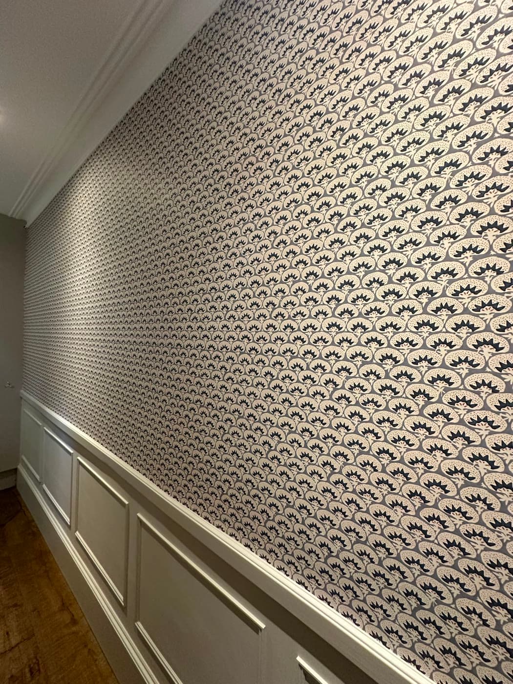Close-up of a decorator spray-painting kitchen cabinet doors to a smooth matt grey finish