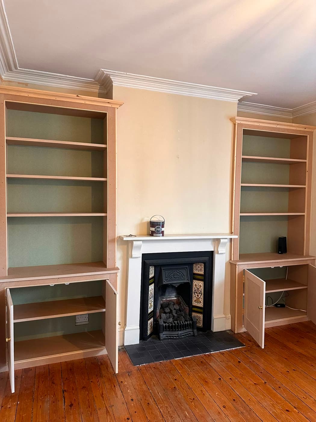 Decorator sanding and filling woodwork and skirting during surface preparation