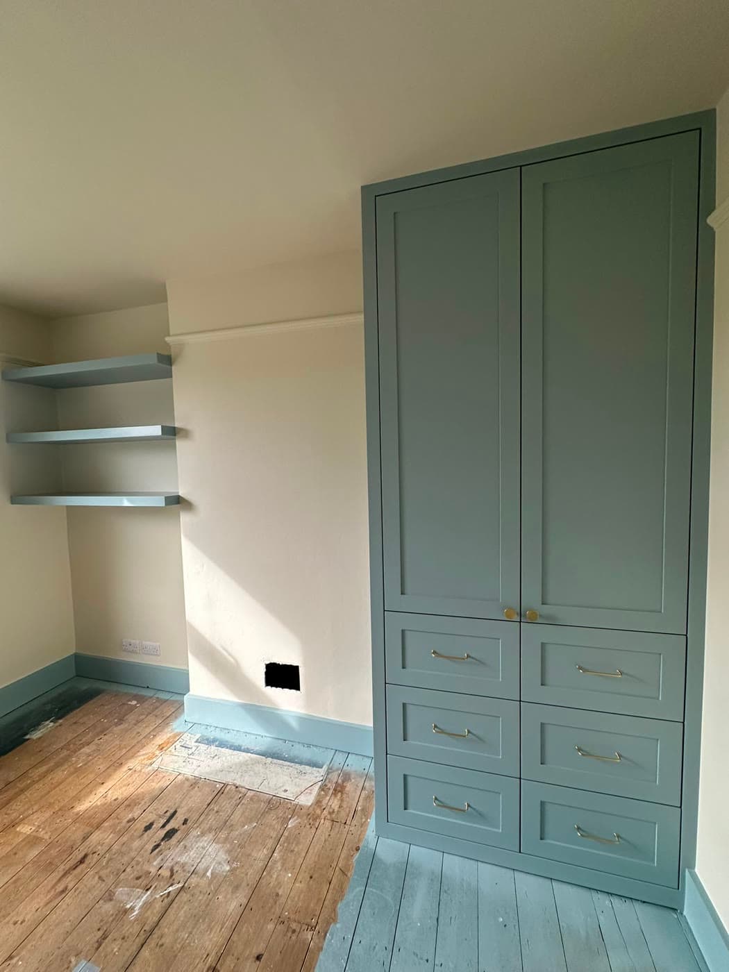 Pristine completed interior repaint of a British hallway and staircase with crisp white woodwork